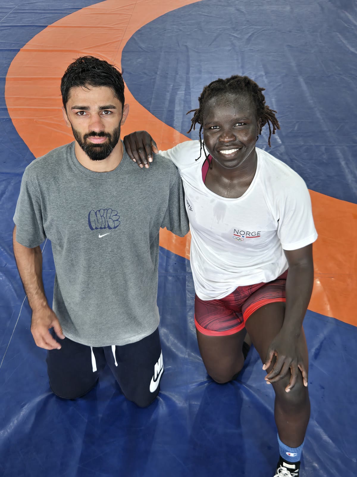 A Norwegian national-team wrestler with a Georgian coach on the orange mat